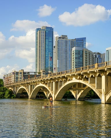Paddleboarder on Lady Bird Lake with Austin skyline